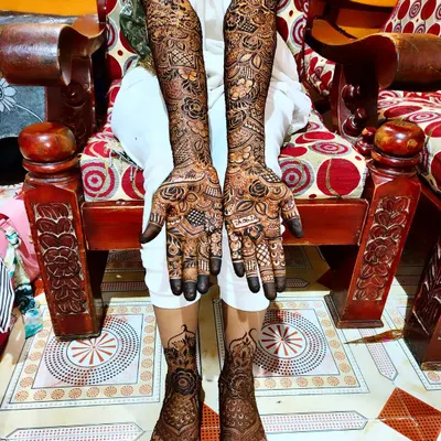 A full view of a complete bridal henna set. The designs on the hands and feet are coordinated to create a harmonious and traditional look, perfect for the wedding ceremony.