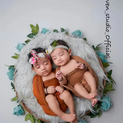 Double the joy, double the love. This portrait of twin newborns, nestled together in a floral wreath, is a beautiful testament to their special bond from the very beginning.