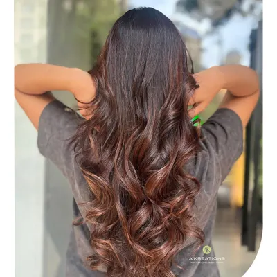 A beautiful example of a rich brown color melt, styled into glossy, soft waves. This look adds depth and movement, creating a truly luxurious feel.