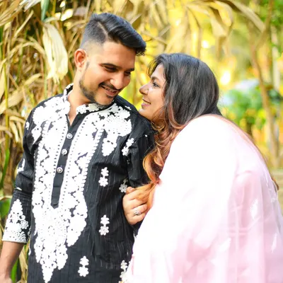 A beautiful, candid moment between a couple, sharing a smile during an outdoor shoot. The soft lighting and natural interaction make this shot feel warm and genuine.