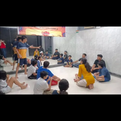 A theatre workshop in session, with students sitting in a circle for a script-reading and character development exercise. This collaborative approach is central to how we create our original plays.