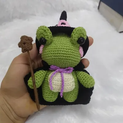 Holding the little wizard frog to show his size. He's a perfect handful of magic, with his little cape and wand all securely stitched on.