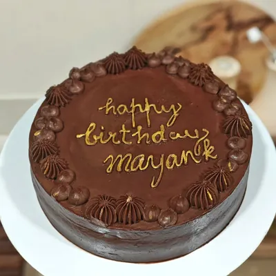 The finished Belgian chocolate and raspberry cake, personalized with a "Happy Birthday" message in gold. A classic flavor combination that's always a crowd-pleaser.
