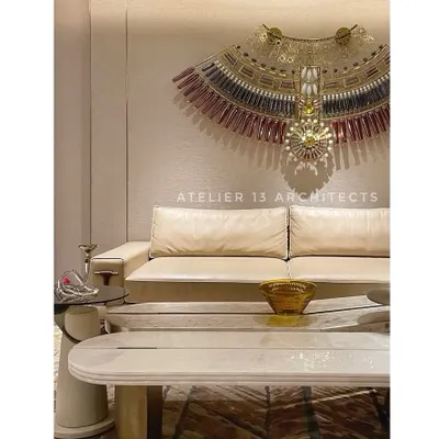 A different perspective of the lounge with the KLOVE STUDIO glass necklace, focusing on the statement marble coffee table with bronze legs. This view shows how we layer different shapes, materials, and finishes to create a cohesive design.