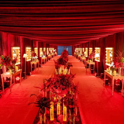 The entrance to the Rogue Romance Sangeet was a dramatic, fully carpeted tunnel draped in red velvet. I lined the walkway with vanity mirrors and floral arrangements, creating a glamorous, backstage-inspired path into the heart of the celebration.