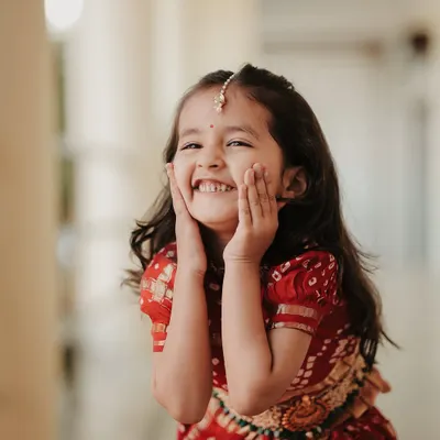 The pure, uncontainable joy of a child at a wedding. This little one's huge smile is infectious and captures the happy, family-friendly atmosphere of the celebration.