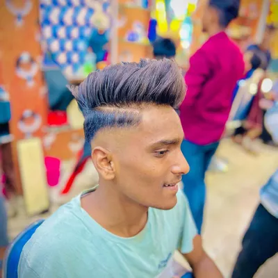 This high fade haircut is perfectly blended into a textured, voluminous top. The sharp line-up at the temple keeps the look clean and modern.