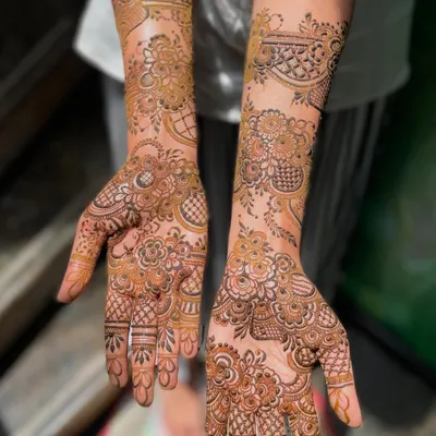 A classic, full-coverage bridal mehendi for bride Heeba. The design extends from the fingertips to the forearms, featuring a mix of floral, paisley, and geometric elements.