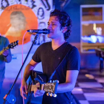 An acoustic performer serenading the crowd. My live music nights offer a more intimate but equally entertaining experience.