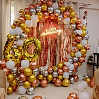 A beautiful round balloon arch in rose gold, gold, and silver for a 40th anniversary celebration. The "Happy Anniversary" neon sign and large marquee numbers create an elegant and memorable photo backdrop.