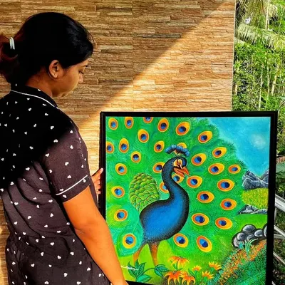 Holding my peacock painting in the sunlight. The natural light really brings out the rich greens and blues of the feathers.