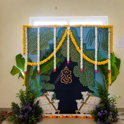 For this housewarming, I created a custom Pichwai-inspired backdrop. The design features traditional cow motifs and a central Ganesha, framed by fresh banana leaves and marigold garlands to create a truly blessed and artistic entrance.