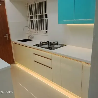 A look at a modern kitchen layout we completed, showcasing a clean and efficient workspace. This design features dual-tone cabinetry, a durable white countertop, and integrated floor and under-cabinet lighting that makes the space feel bright and spacious.