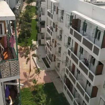 An aerial view of the Happinest project in Avadi, Chennai. The layout of the buildings is designed to create green, shaded walkways in between, fostering a sense of community and ensuring that each home has good access to light and air.