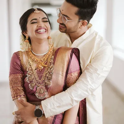 The pure, unadulterated joy of a wedding day. Namritha's laughter is infectious as she is embraced by her groom, Nandakishore, during their beautiful Kerala wedding.