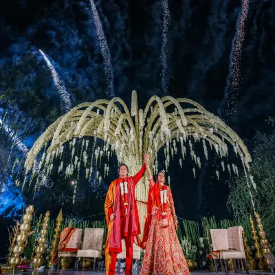 A spectacular Varmala ceremony under a custom-designed, tree-like structure adorned with flowers, culminating in a dazzling fireworks display. This is the kind of unforgettable moment I create.
