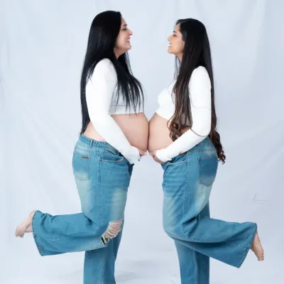 Two bumps are better than one. We love this joyful shot of two sisters showing off their matching baby bumps in a fun, casual maternity shoot.