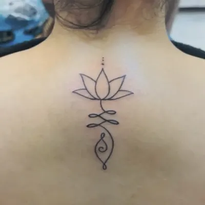 A perfect example of a "one-liner" tattoo. This design combines a lotus and a Unalome symbol in a single, unbroken line on the client's back. It's simple, elegant, and deeply meaningful.
