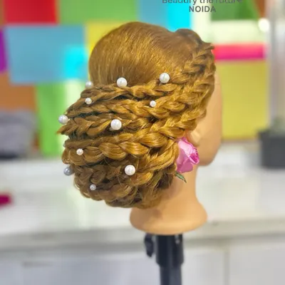 This intricate braided bun, adorned with pearls, is a perfect example of the advanced hairstyling techniques we teach. It's a highly sought-after skill for bridal and formal events.