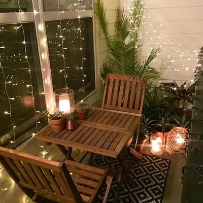 This balcony is all about creating a cozy, romantic atmosphere. I used curtains of fairy lights and candle-lit lanterns to enclose the small bistro set, turning it into a perfect spot for an intimate dinner.