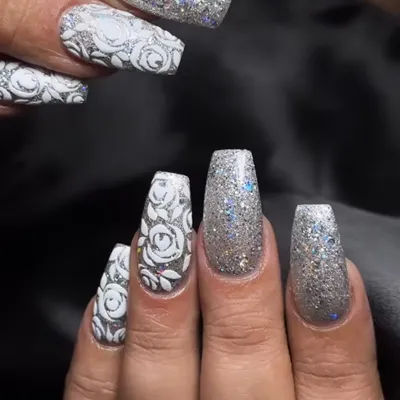 A full-coverage silver glitter nail with a 3D white rose design. This is maximum sparkle and texture.