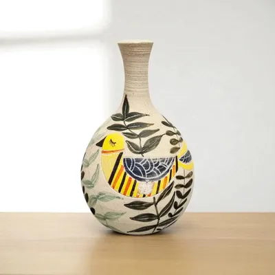 This hand-painted ceramic vase is a lovely piece of art, featuring a colorful bird design. It's more than just a container for flowers; it's a handcrafted item made with care and attention to detail.