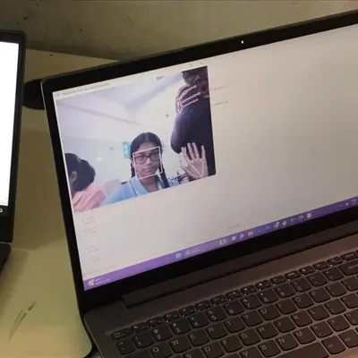 A student's laptop screen shows a Python application using computer vision to detect and track hand movements in real-time.