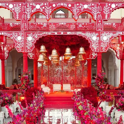 For 'Kaanch Bagh', I created my own version of a Sheesh Mahal (Palace of Mirrors) in a stunning shade of red. The intricate structure, adorned with traditional white motifs, a ceiling of red florals, and hanging temple bells, served as a breathtaking mandap for a sacred ceremony.