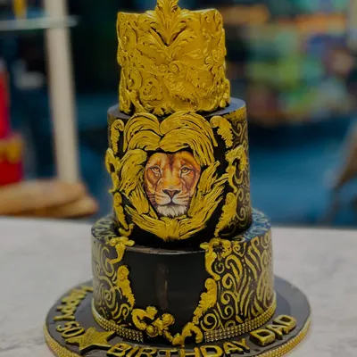A majestic cake for a dad who is the king of the family. This three-tier black and gold cake features intricate baroque details and a powerful lion face, symbolizing strength and royalty.