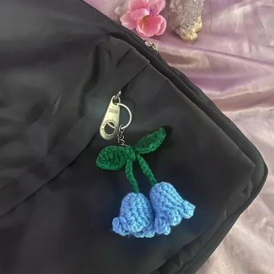A handmade bluebell flower charm clipped onto a backpack zipper. I love how the blue pops against the black.