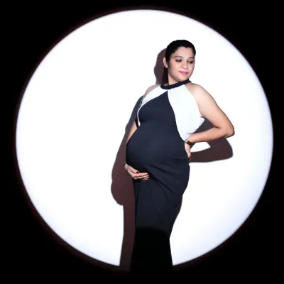 This classic pose, framed within a circle of light, is perfect for creating a sophisticated and memorable maternity portrait. It emphasizes the beautiful curves of pregnancy in a simple yet powerful way.