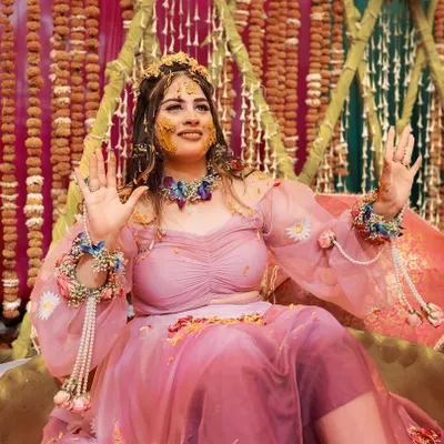 A radiant bride enjoying her Haldi ceremony. This close-up captures her joyful expression as she is covered in turmeric, showcasing the fun and vibrant spirit of the event.