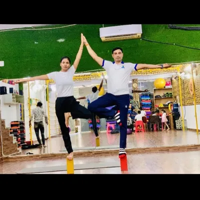 Finding balance together. This couple is using yoga blocks to master a partner tree pose, showing great teamwork and synchronization.