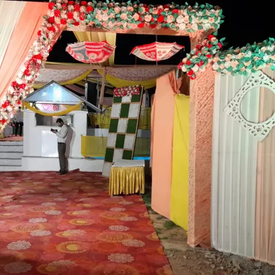 Your guests' first impression matters. We design beautiful and welcoming entrances, like this one featuring a colorful floral arch, traditional decorative umbrellas, and flowing drapes to set a festive tone for the wedding celebration.