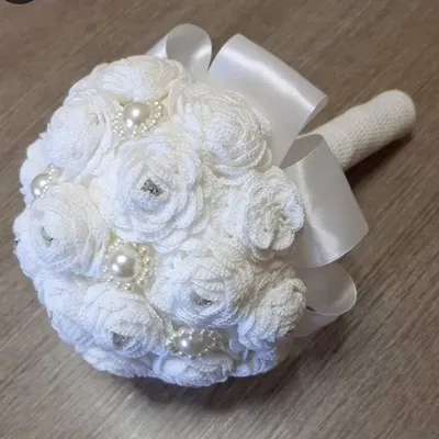 A bridal bouquet that will never wilt. I crafted this beautiful bouquet from dozens of individual white crochet roses, each embellished with pearls and rhinestones and tied with a satin ribbon.