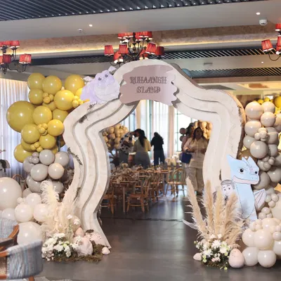 The grand entrance to "Ruhaansh's Dragon Island," where a custom archway, earthy-toned balloons, and pampas grass welcomed guests to a world of adventure.