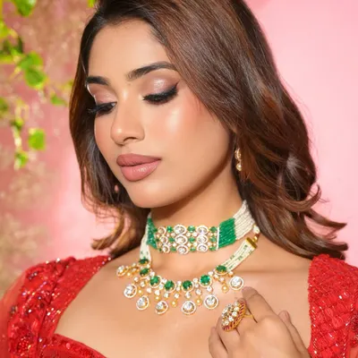 The sister of the groom looking radiant in red. This close-up shows the detailed eye makeup and flawless skin finish that gives her a main character energy.
