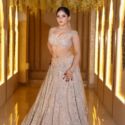 This is a perfect example of a modern reception look. The heavily embellished silver lehenga is balanced with soft, smokey eyes, a nude lip, and a sleek hairstyle, creating a look that is both glamorous and elegant.