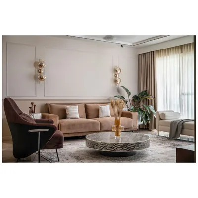 The living area of our Kanasu project was designed for modern comfort. We used a dual-toned wall and a mix of furniture textures, like this plush brown sofa and patterned center table, to create a welcoming space that takes full advantage of the apartment's natural light.