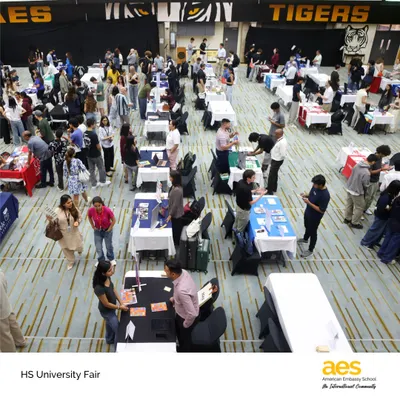 An overhead view of our bustling HS University Fair, showcasing the scale of the event. We ensure our students have ample opportunities to explore a wide range of international and domestic college options right here on campus.