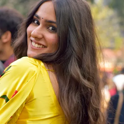 A joyful, over the shoulder smile captured during a Pride event. This candid street portrait is all about capturing authentic happiness and confidence.