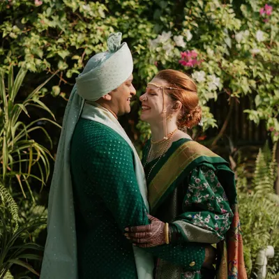 A beautiful, happy moment between the bride and groom during their Marathi wedding ceremony. Rach looks radiant in her traditional Paithani Nauvari saree, and Viraj is handsome in his custom green sherwani.