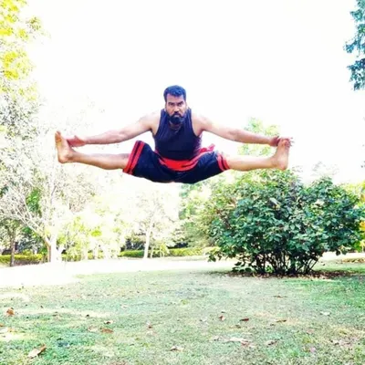 Master Moideen Rafi demonstrating a flying split, a testament to the incredible martial arts flexibility and power developed through years of dedicated Kalaripayattu practice.