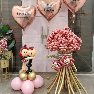 A beautiful and romantic arrangement for a 30th anniversary. This set includes a large balloon flower bouquet, a sculpted couple figurine, and personalized rose gold heart balloons to celebrate a "Most Loved Couple."