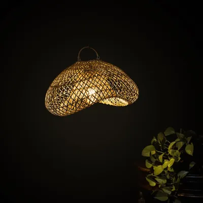 This lit sculptural lamp casts a mesmerizing glow, its light filtering through the complex, wavy weave. It is designed not just to illuminate a space, but to interact with it, creating moving patterns of light.