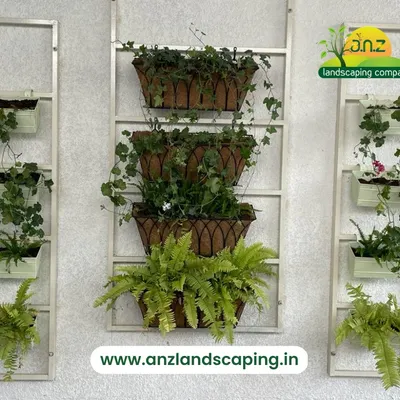 This stylish wall-mounted planter system uses a combination of hanging baskets and rectangular pots on a ladder-like frame. It's an elegant and versatile solution for adding greenery to a wall without a full installation.