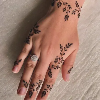 This delicate leafy vine is a perfect example of minimalist henna art. It gracefully adorns the hand and fingers, making it a chic choice for any occasion.