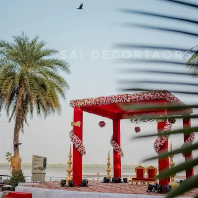 A stunning red vidhi mandap set up right by the water. This open-air design allows the natural beauty of the location to be part of your ceremony, creating an unforgettable experience.