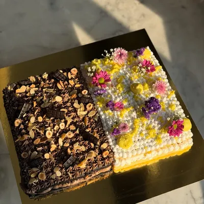 Our signature half and half sheet cake, perfect for large gatherings. This one features a rich chocolate hazelnut side and a light, floral-decorated vanilla side.