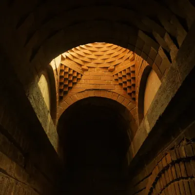 Light streams through the oculus of this intricate brick dome, creating a dramatic play of light and shadow on the corbelled geometry below. This is architecture as an experience.
